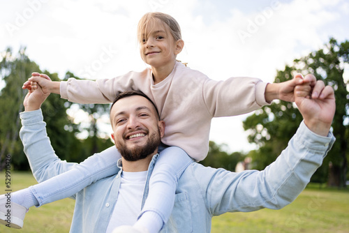 Happy father and child having fun playing in park. Smiling young dad and daughter spending time together in nature. Family time, relationships concept.