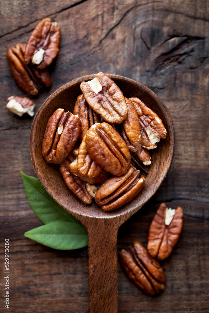 Shelled Pecan nuts in a wooden spoon bowl Shelled Pecan nuts in a wooden spoon bowl