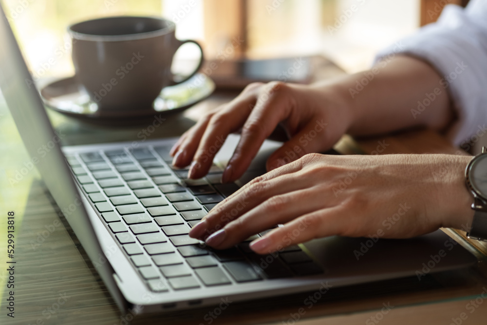 Close up image of woman hands typing on laptop computer keyboard and surfing the internet on office table, online, working, business and technology, internet network communication concept. Close up image of woman hands typing on laptop computer keyboard and surfing the internet on office table, online, working, business and technology, internet network communication concept.