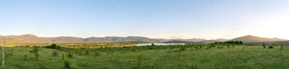 Beautiful green hills and valley in setting sun light. Great design for any purposes. Beautiful summer landscape panorama. Nature background. Travel concept. Copy space.