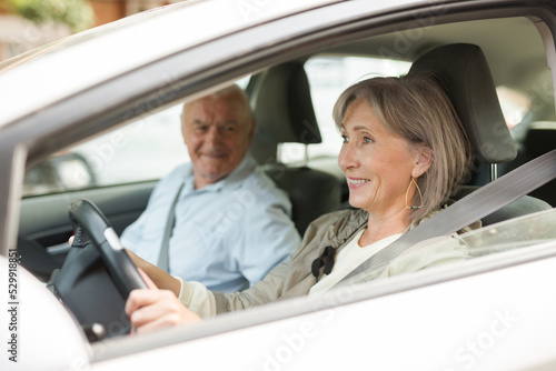 Mature couple sitting in car. Woman sitting at driver's seat.