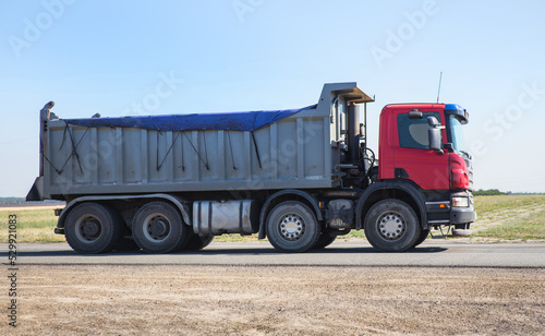 Large dump truck moving on the road © Yuri Bizgaimer