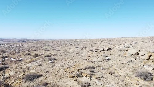 Tracking shot over vast and empty desert in northern New Mexico with clear skies and patches of snow