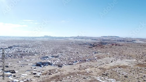 Tracking shot over snow covered rocks in high desert in northern New Mexico with clear blue skies
