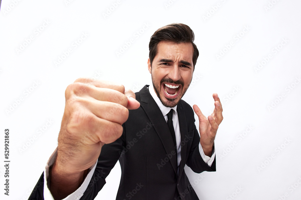 Portrait of a man in an expensive business suit close-up wide-angle lens pulling his hands to fight into the camera with his mouth open screaming his fists up on a white background, copy space Portrait of a man in an expensive business suit close-up wide-angle lens pulling his hands to fight into the camera with his mouth open screaming his fists up on a white background, copy space