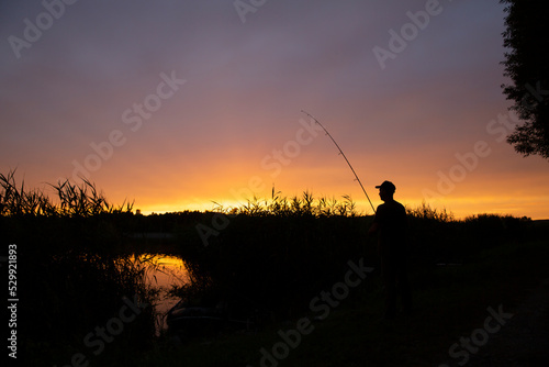 Angling fish fishing against the background of sunset © bluejeansw