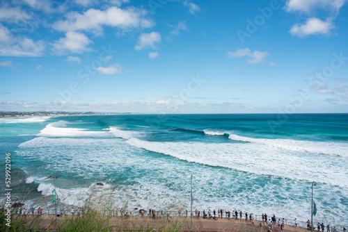 Canvas Print Spectators lining the beach watching a surfing competition.