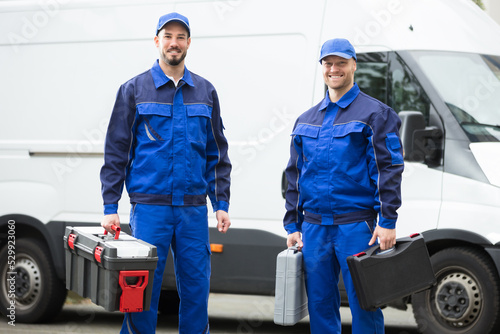 Happy Male Workers Holding Toolboxes photo