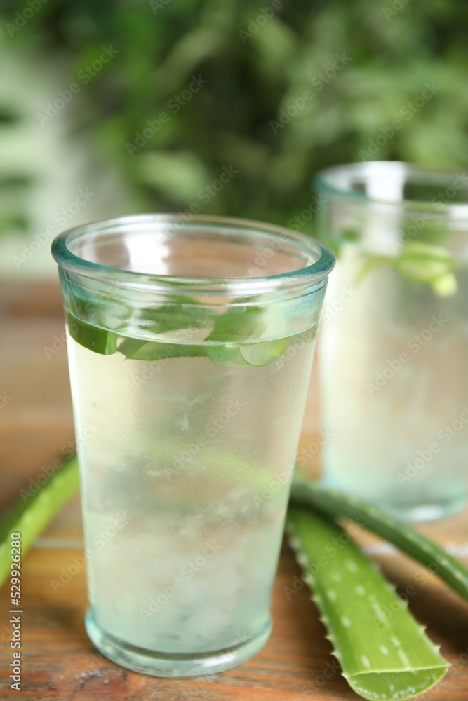 Fresh aloe drink in glasses and leaves on wooden table Fresh aloe drink in glasses and leaves on wooden table