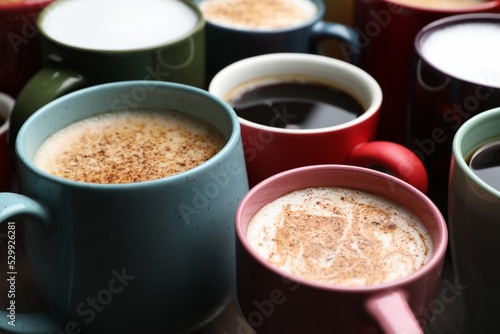 Many different cups with aromatic hot coffee on table, closeup