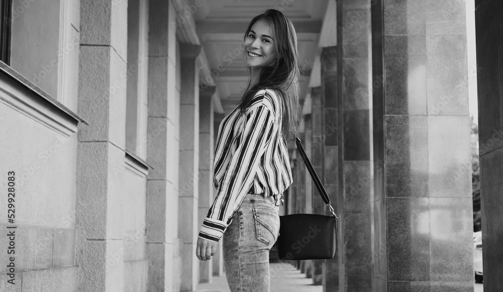 Street Style Outdoors Portrait of Beautiful Girl. Fashion Woman Smiling. She wearing Print Shirt, Jeans, Bag. Lifestyle Street Style Outdoors Portrait of Beautiful Girl. Fashion Woman Smiling. She wearing Print Shirt, Jeans, Bag. Lifestyle