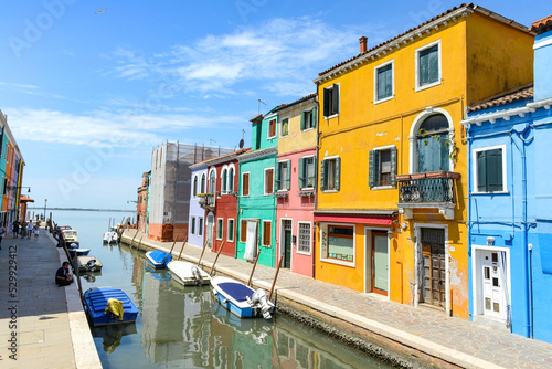 Tourists and Colorful houses on the canal in Burano island, Venice, Italy.
