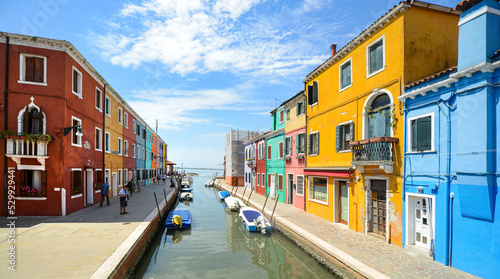 Tourists among the sovereign shops on the main street of burano Island,  Colorful houses on the canal. Venice, Italy. © opasstudio