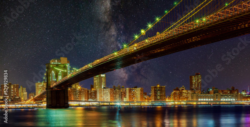 Brooklyn Bridge by night with skyscrapers famous New York panoramic view of Manhattan skyline © ungvar