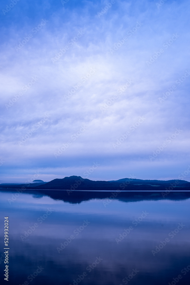 青く染まる夜明けの湖。北海道の屈斜路湖。
