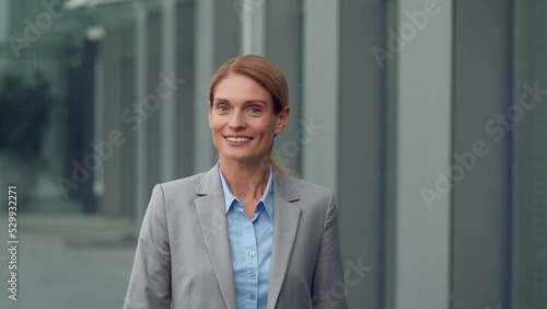 Wallpaper Mural Successful career concept. Happy middle aged business woman in suit walking forward near office building, follow shot Torontodigital.ca
