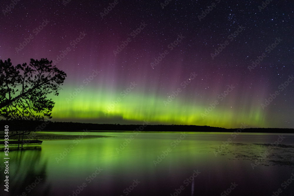 Northern Lights erupt in brilliant Aurora sky over Northern Minnesota Lake