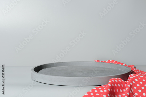 grey concrete tray made of cement as stand under plate. empty scene for food placement. mock up for food setting. red kitchen napkin photo