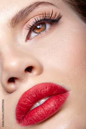 Closeup shot of human female face with pink eyes makeup and red lips