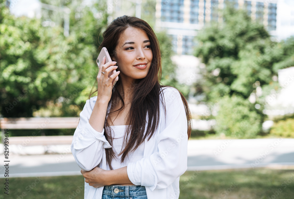 Portrait of young asian woman student with long hair using mobile phone in city park Portrait of young asian woman student with long hair using mobile phone in city park