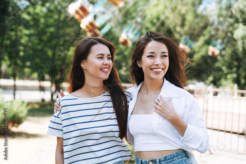 Young women with long hair friends having fun at amusement park