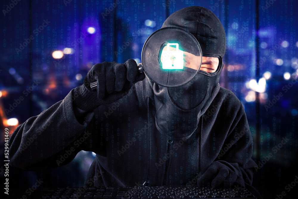 Hacker use magnifier to look at padlock security Hacker use magnifier to look at padlock security