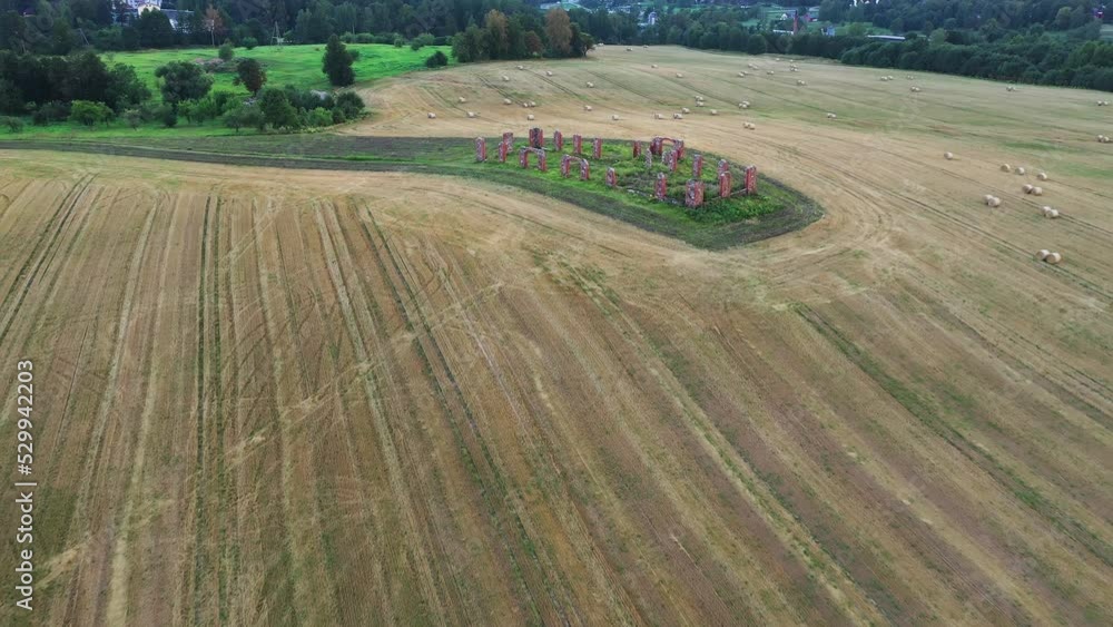 Smiltene Stonehenge surrounded by wheat fields and haybales, aerial fly toward view Smiltene Stonehenge surrounded by wheat fields and haybales, aerial fly toward view