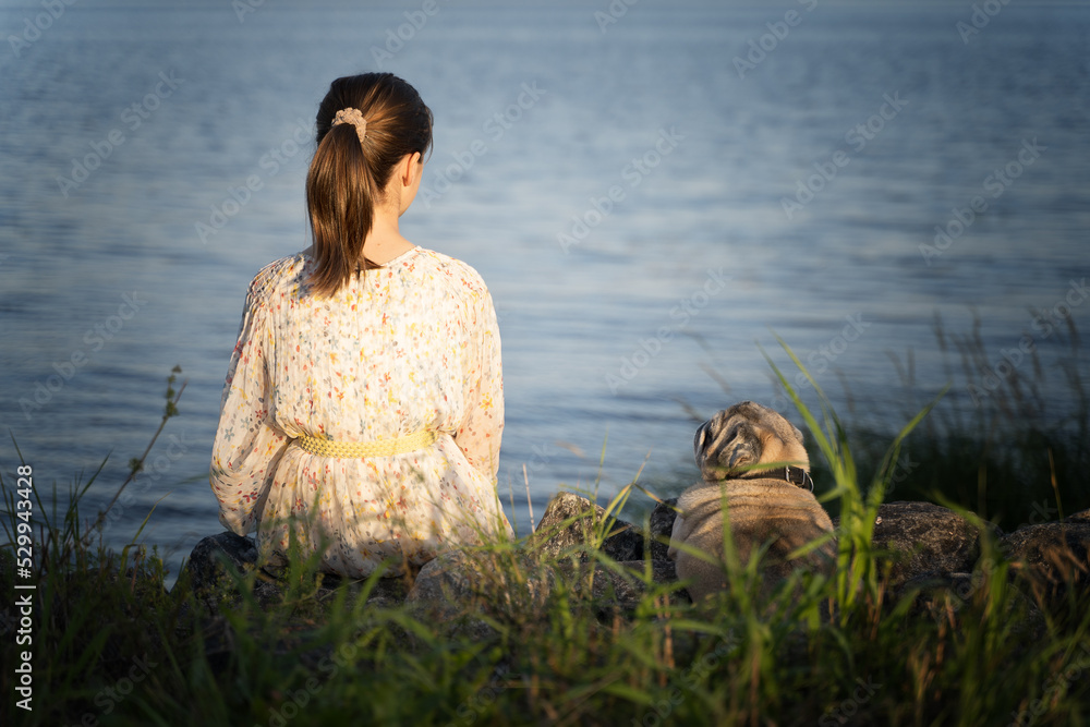 Fototapeta premium Portrait of a girl and her little dog, rear view