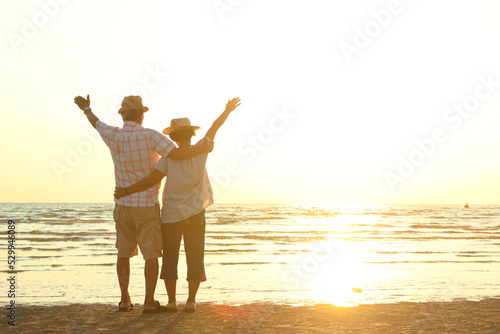 Asian elderly couples enjoy traveling and living. The two were cuddling at the beach in the evening. The concept of tourism for the elderly. life in retirement. Copy space