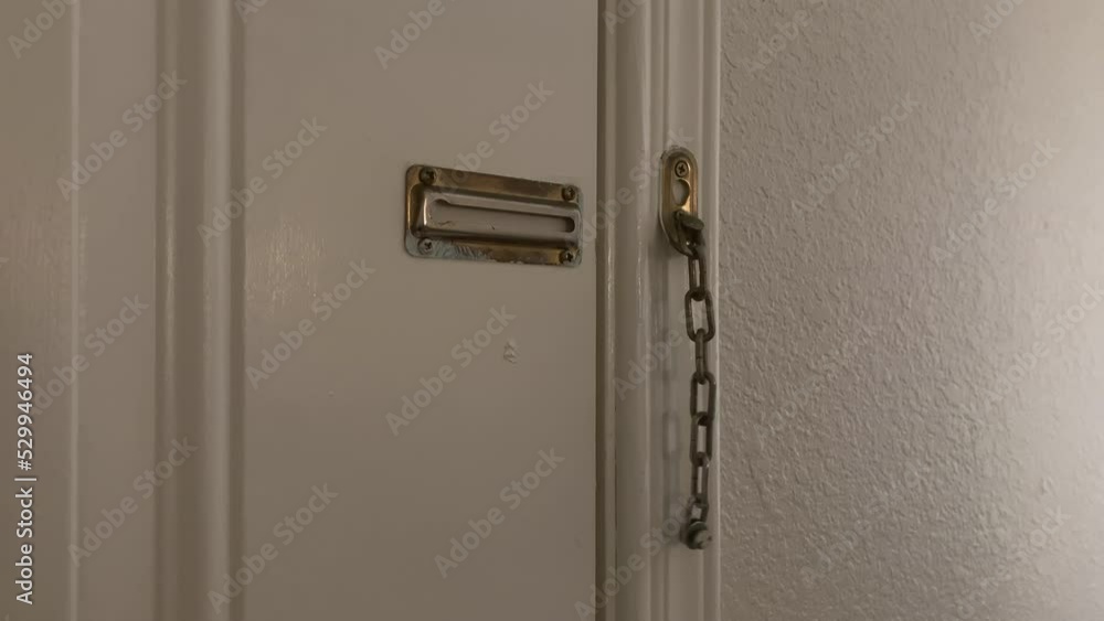 Tan Male Hand Unlocking Brass Security Door Chain Guard Tan Male Hand Unlocking Brass Security Door Chain Guard