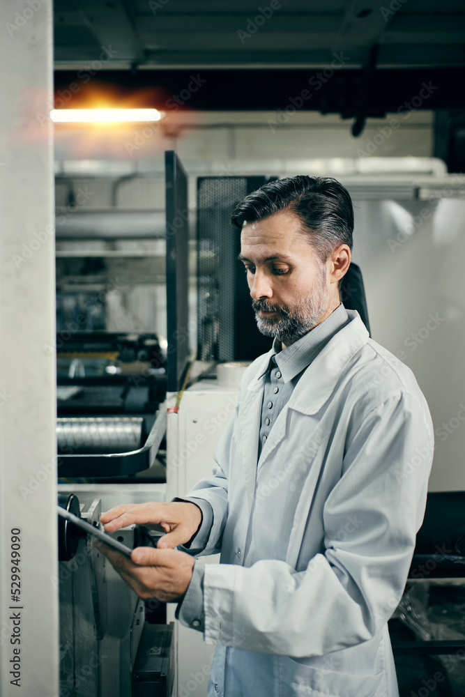 Engineer with tablet working at polymer factory