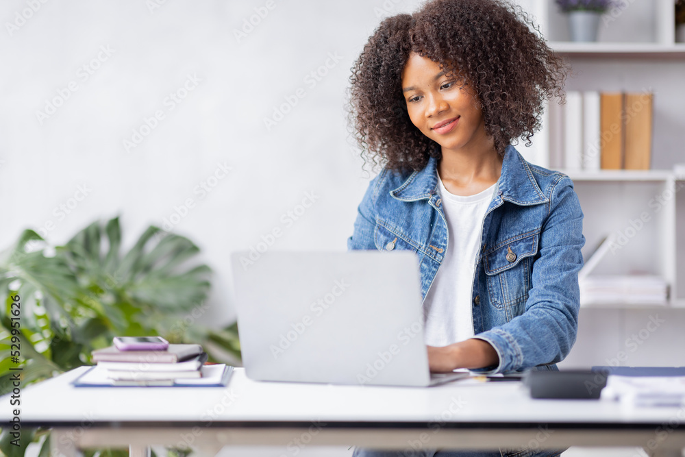 Creative young african american woman working on laptop in her studio,Doing accounting analysis report real estate investment data, Financial and tax systems concept. Creative young african american woman working on laptop in her studio,Doing accounting analysis report real estate investment data, Financial and tax systems concept.