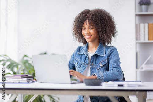 Creative young african american woman working on laptop in her studio,Doing accounting analysis report real estate investment data, Financial and tax systems concept.