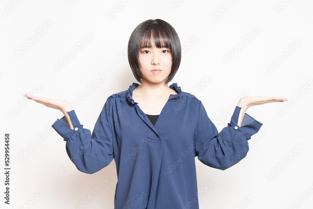 白背景の前で案内のポーズをする若い女性 白背景の前で案内のポーズをする若い女性