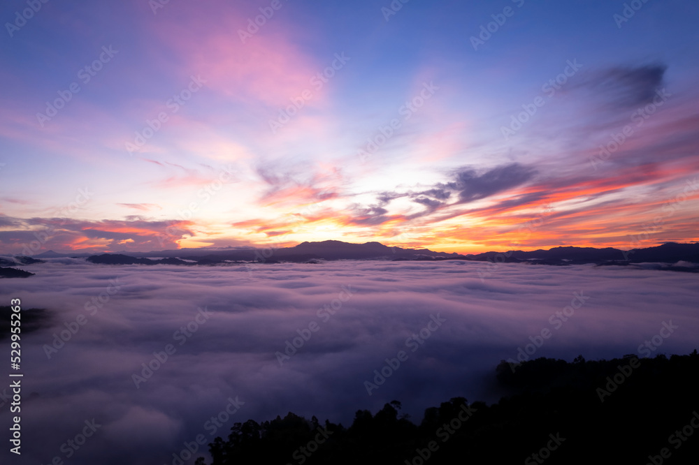 Aerial view of flowing fog waves on mountain tropical rainforest beautiful sunrise or sunset sky,Bird eye view image over the clouds Amazing nature background with clouds and mountains in Thailand Aerial view of flowing fog waves on mountain tropical rainforest beautiful sunrise or sunset sky,Bird eye view image over the clouds Amazing nature background with clouds and mountains in Thailand