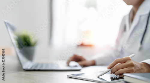 Female doctor working on digital tablet, analyzing and report treatment effect at office