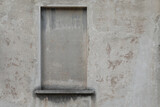 Concret wall of a house with a bricked up window, grey and rough surface, wall for a background