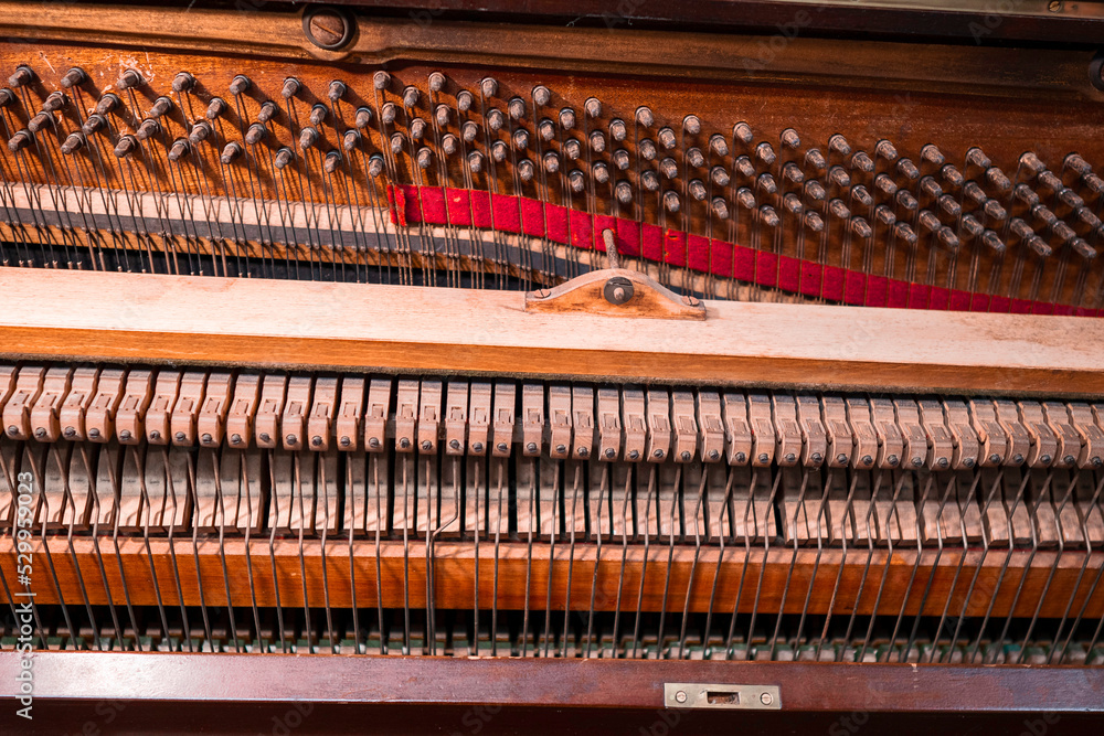 Internal part of piano with brass metal strings and wooden hammer. Old fashion music instrument for performance. Selective focus. Internal part of piano with brass metal strings and wooden hammer. Old fashion music instrument for performance. Selective focus.