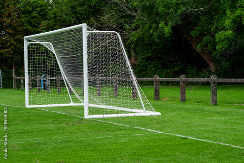 Side of football of soccer goal post with net in focus. Field out of focus. Sport background and equipment. © mark_gusev