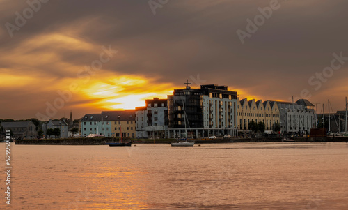 Stunning sunset over Galway city, Ireland. Beautiful dramatic sky over The Long Walk area by the Docks. Warm and cool tone. Popular town on West coast.