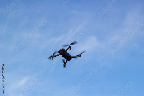 The quadcopter is flying in a blue sky.