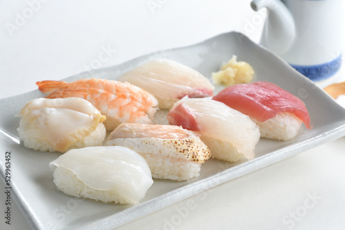 Sushi Set nigiri sashimi and on white plate with soy sauce bottle over white background-Jananese Food