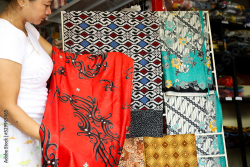 Indonesian batik cloth, Asian women choose batik motifs at batik cloth shops and umkm product in Indonesia photo