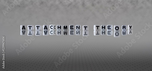 attachment theory word or concept represented by black and white letter cubes on a grey horizon background stretching to infinity photo