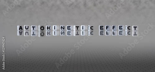 autokinetic effect word or concept represented by black and white letter cubes on a grey horizon background stretching to infinity photo