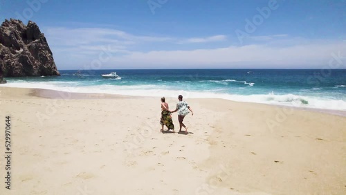 aerial drone view of a couple running and kissing passionately by the beach in Cabo San Lucas, Baja California. romantic beach like in paradise, mexico. 4K videos.