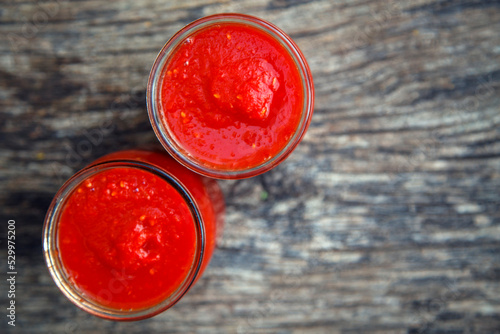 Ready tomato paste in a jar on the table. Tomato ketchup sauce in a glass bowl. The concept of sauces, seasonings, preservation.