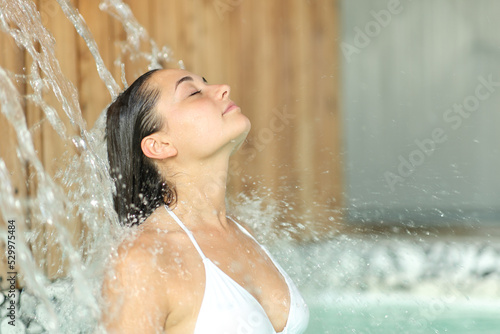 Relaxed woman breathing under water jet in spa