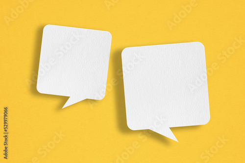 two blank white speech bubble   paper cut,  on grunge yellow paper background. Conceptual image about communication and social media