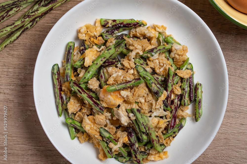 Stir fried Yardlong bean with eggs on wooden background Stir fried Yardlong bean with eggs on wooden background